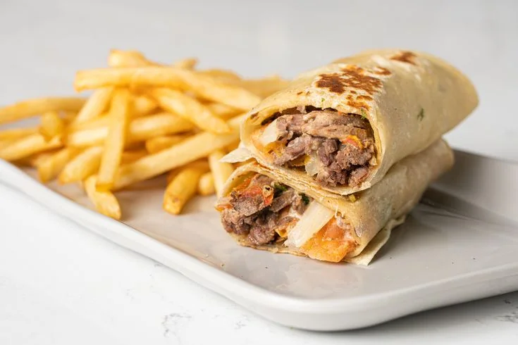 Grilled meat wrap served with fries